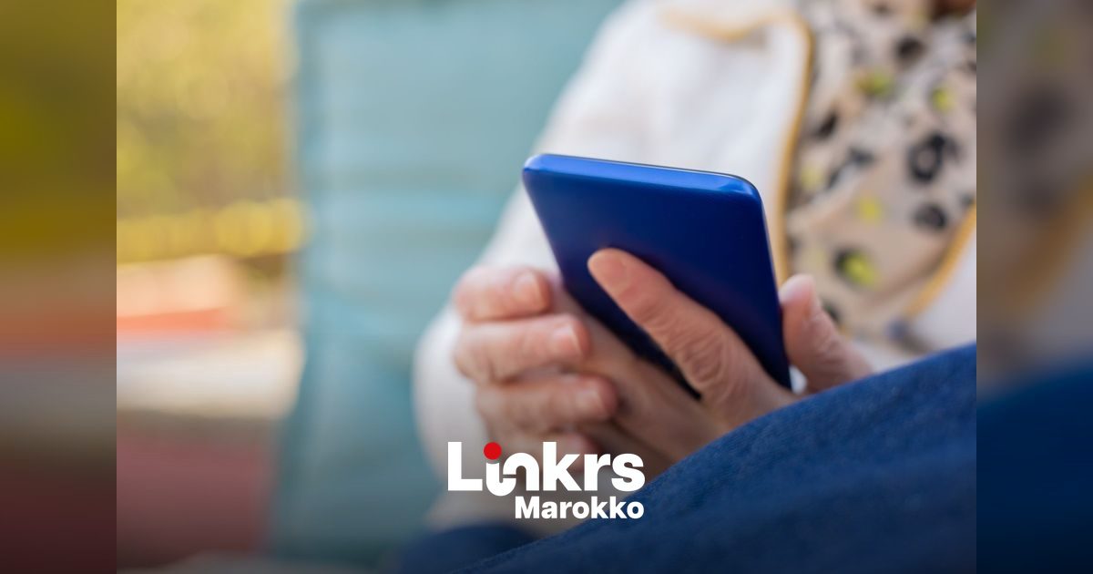 Persoon die op een smartphone door sociale media scrolt met nieuwsberichten