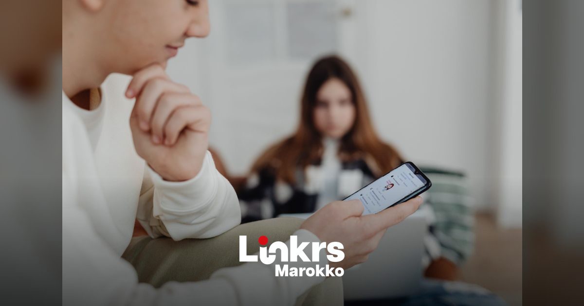 Marokkaanse jongere bekijkt sociale media op een smartphone